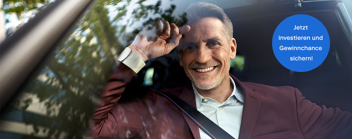 Mann sitzt lächelnd in seinem BMW